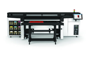 A large printer with many shelves in the background.